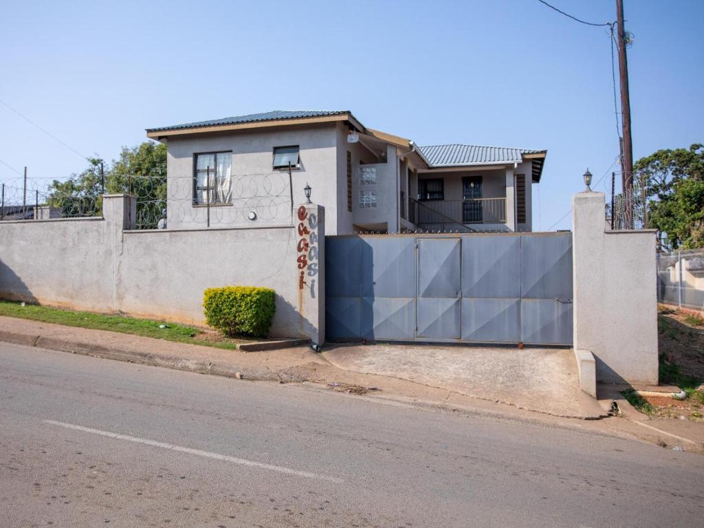 a house with a gate on the side of a street at Ekasi Apartments in Mbabane