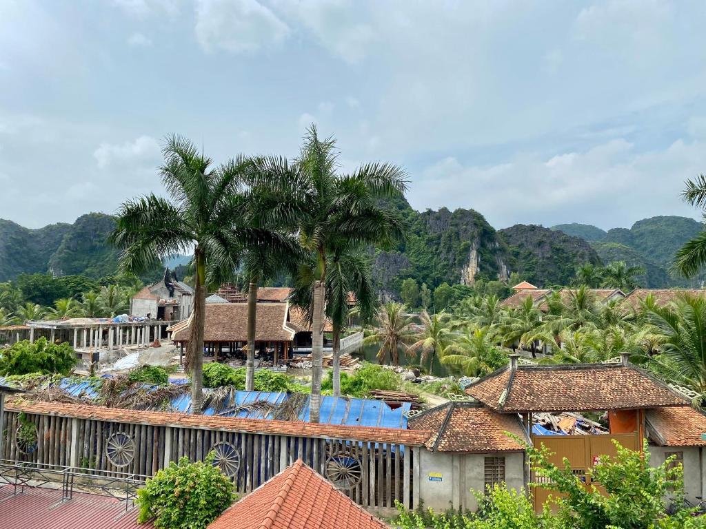 a view of a resort with palm trees and houses at Tam Coc Elegance House in Ninh Binh