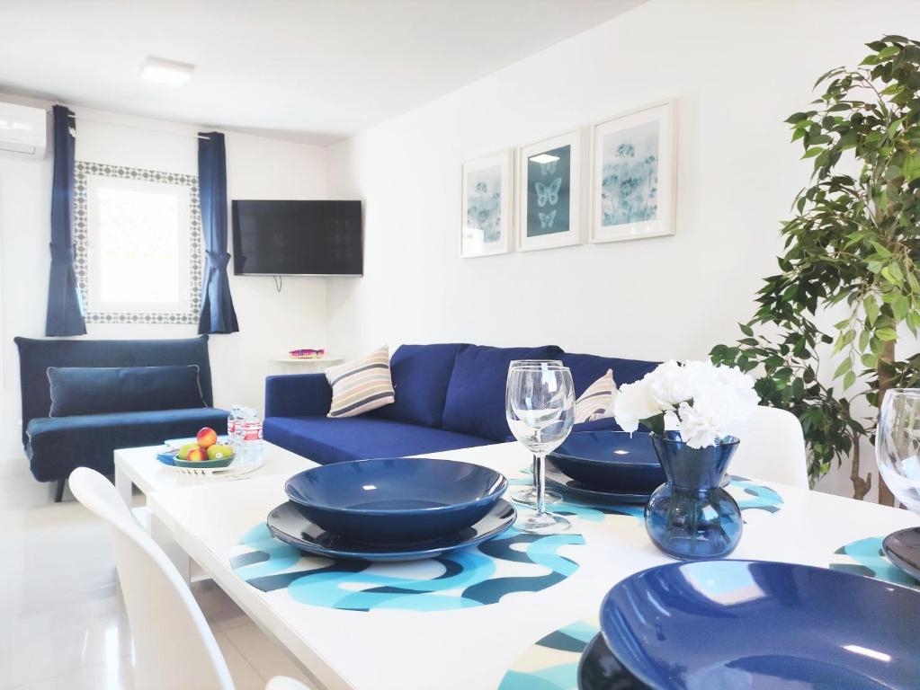 ein Wohnzimmer mit einem Tisch und einem blauen Sofa in der Unterkunft Marbella Center Apartment in Marbella
