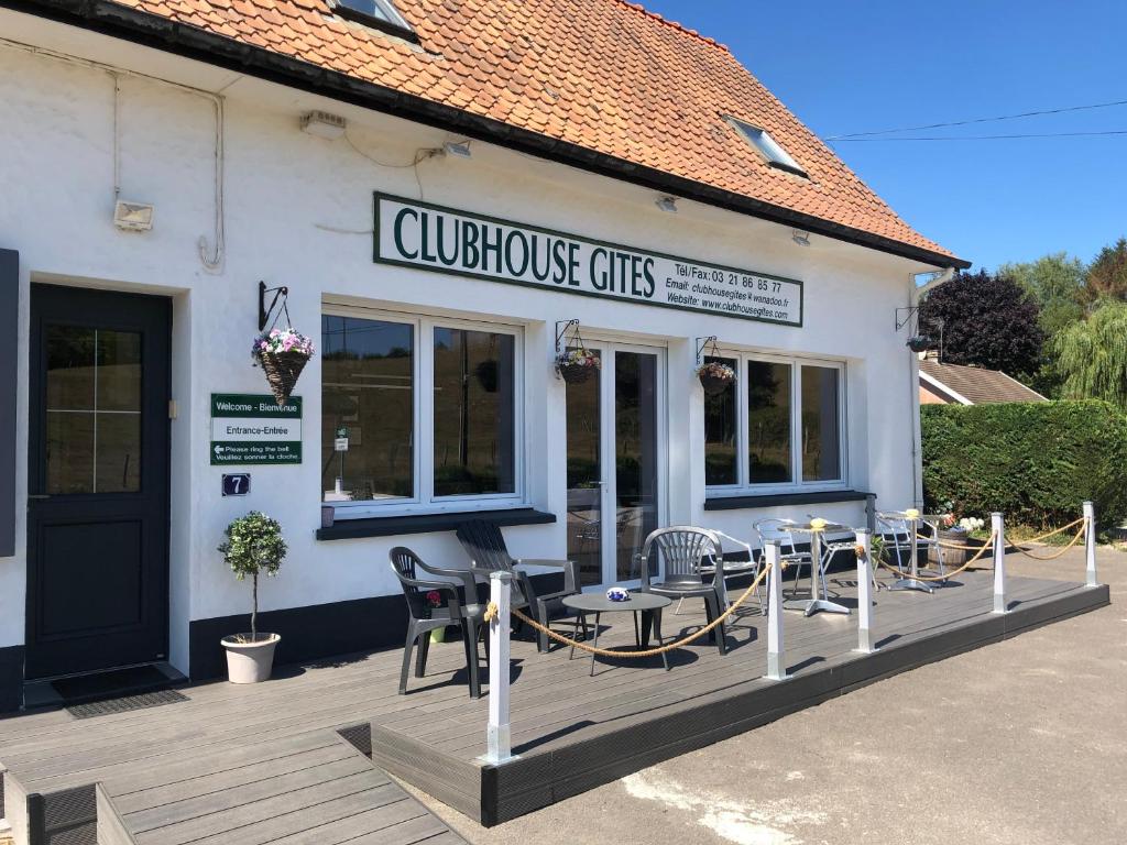 ein Restaurant mit Tischen und Stühlen auf einer Terrasse in der Unterkunft Clubhouse Gites in Beussent