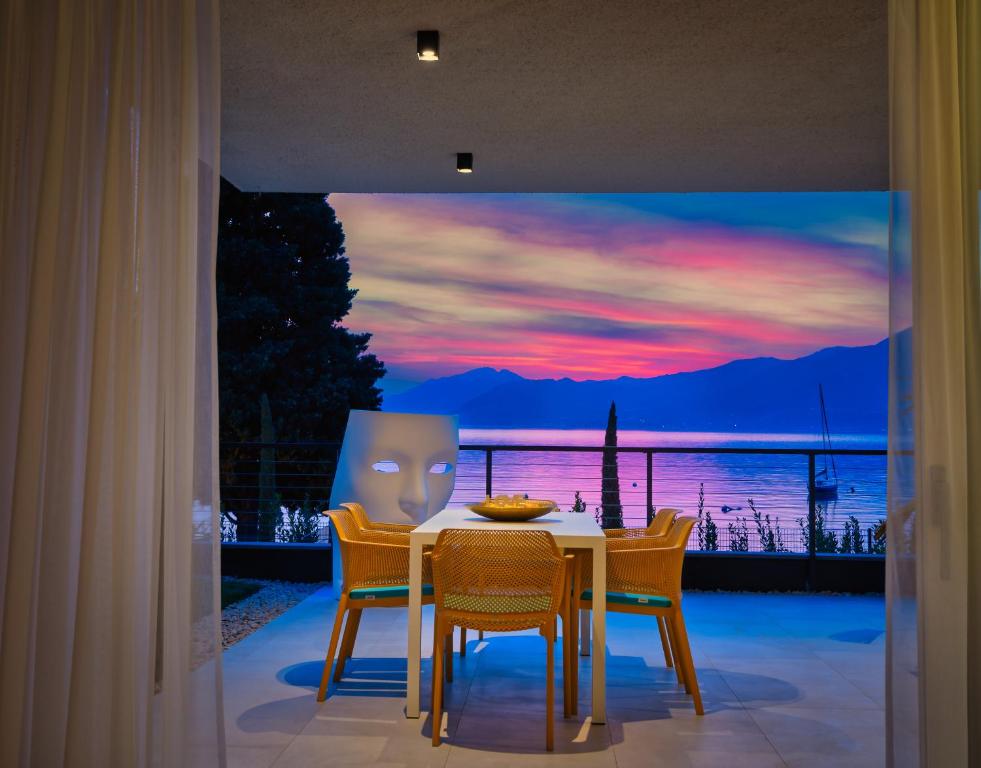 a dining room with a table and chairs and a painting at IL SOGNO al Lago di Garda in Torri del Benaco