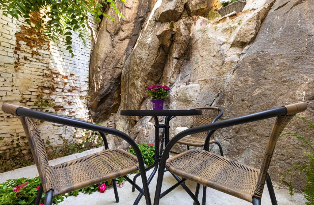 due sedie e un tavolo di fronte a una parete di roccia di The Old Town Vintage 2-Bedroom Jewel a Plovdiv
