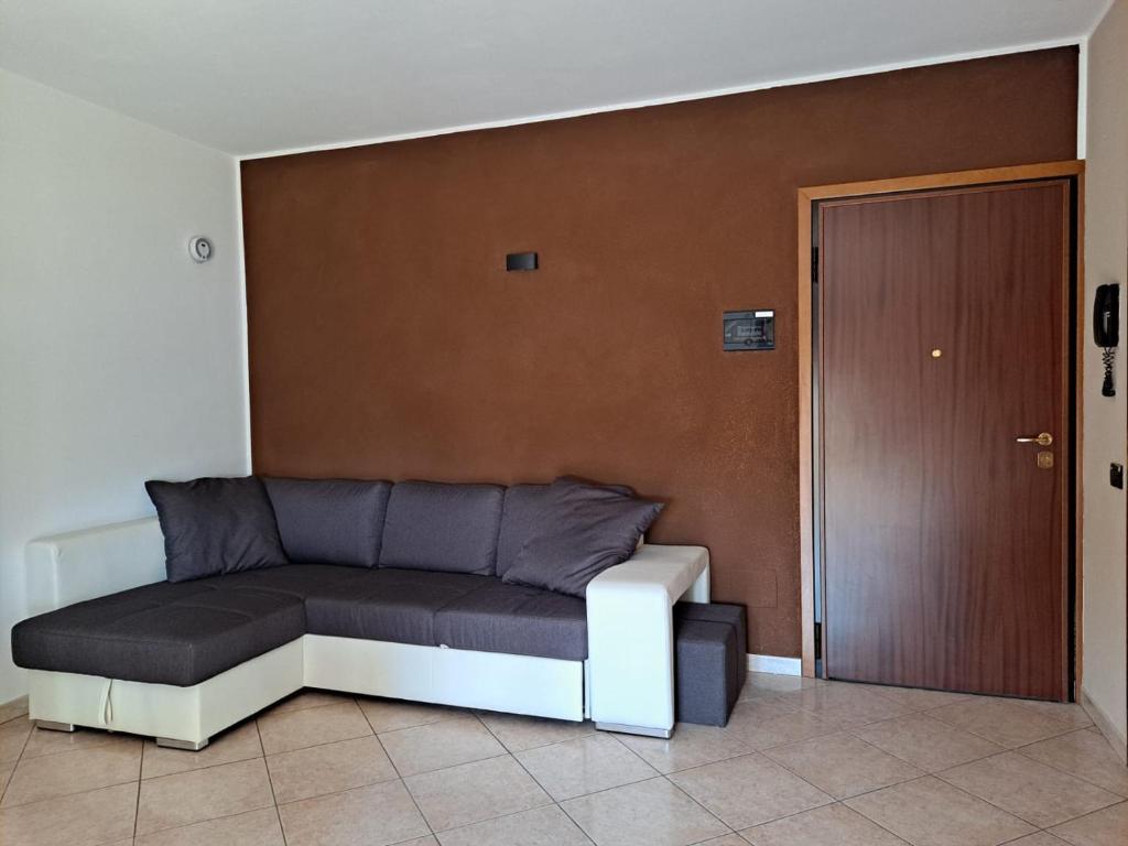 kanapę siedzącą w pokoju obok drzwi w obiekcie Appartamento Roverella w mieście Rovigo