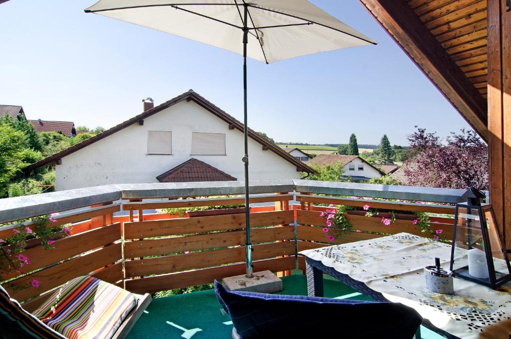 un patio con mesa y sombrilla en Ferienwohnung Renate, 
