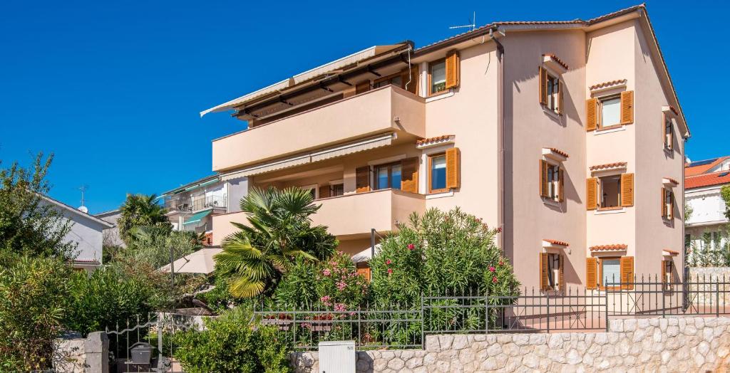 a building with a blue sky in the background at Apartments by the sea Malinska, Krk - 19227 in Malinska