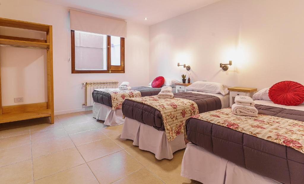 pokój hotelowy z 3 łóżkami i oknem w obiekcie Isla Bonita Suites w mieście Ushuaia