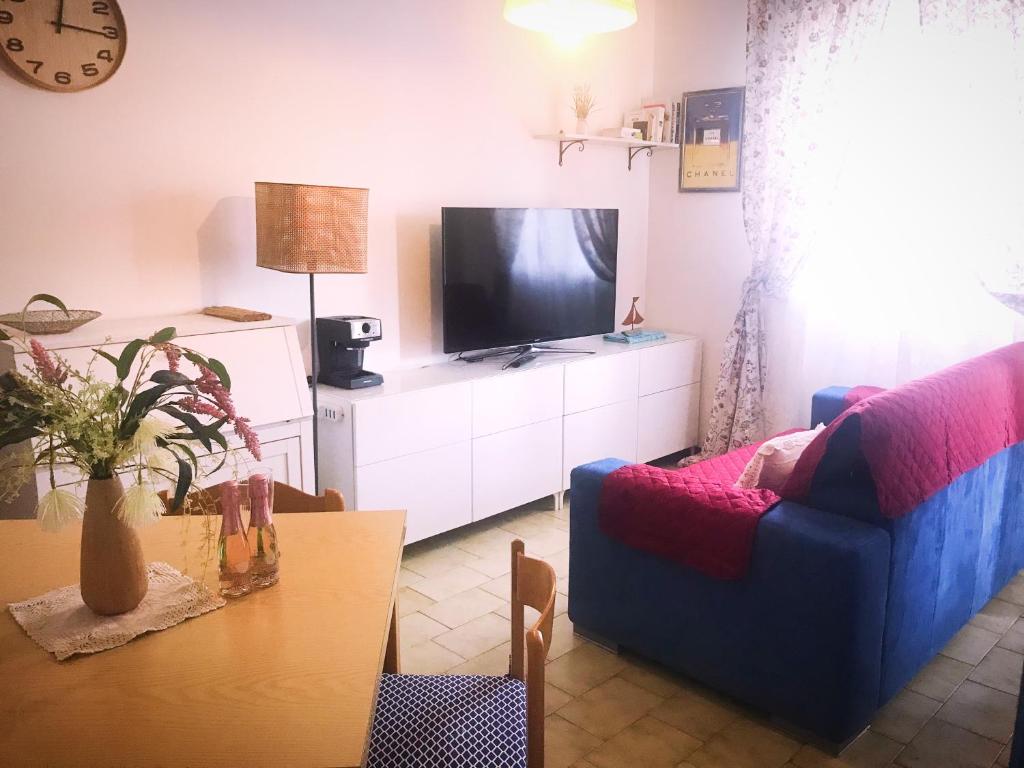 a living room with a blue couch and a tv at Bali in Abruzzo in Silvi Marina