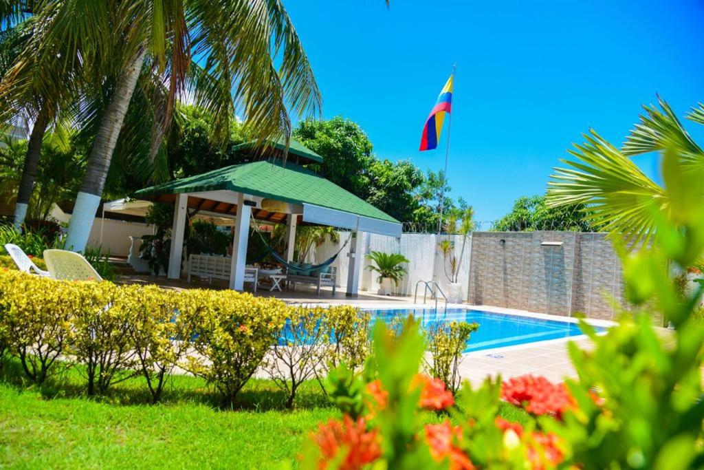 a villa with a swimming pool and palm trees at VG Villa Gloria in Santa Marta