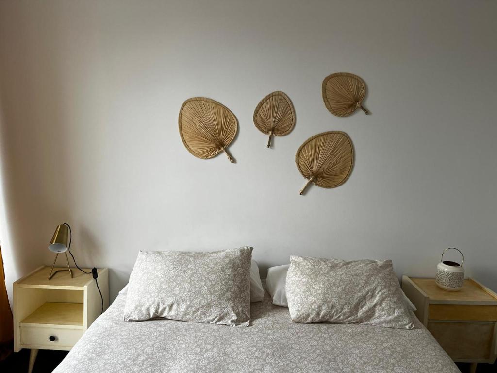 sypialnia z łóżkiem z trzema kapeluszami na ścianie w obiekcie Portas d'Água - Apartamento entre o Mar e a Ria w mieście Gafanha da Nazaré