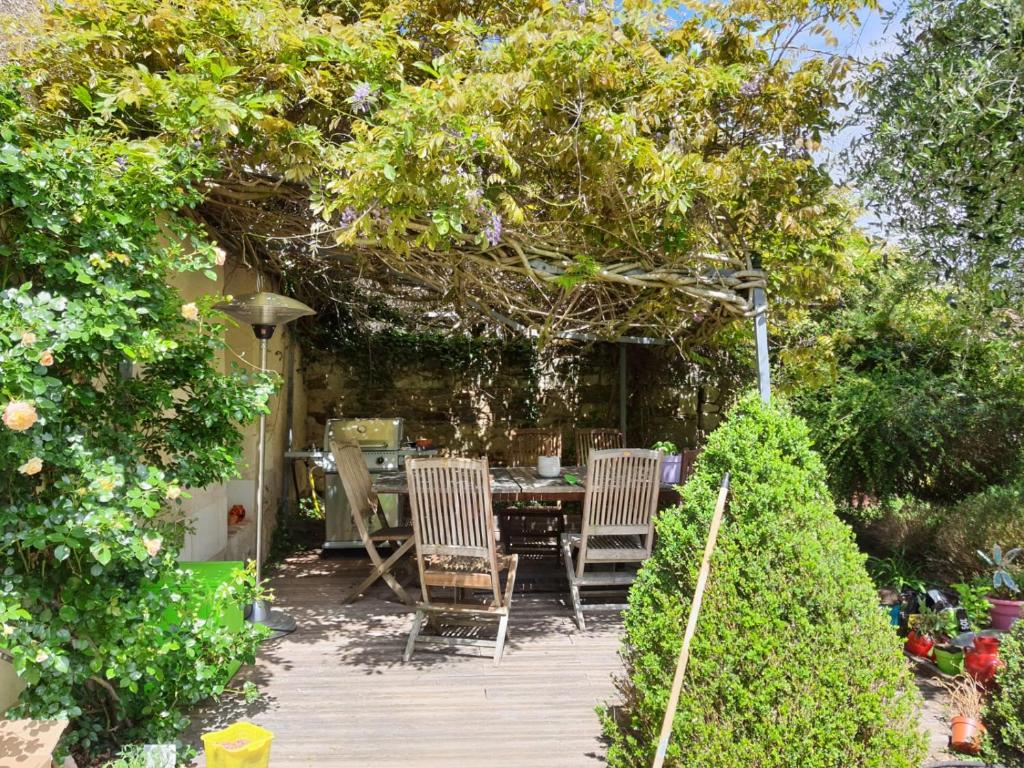 eine Holzterrasse mit Stühlen und einem Tisch im Garten in der Unterkunft VILLA DE SOUZA in Bouillé-Loretz