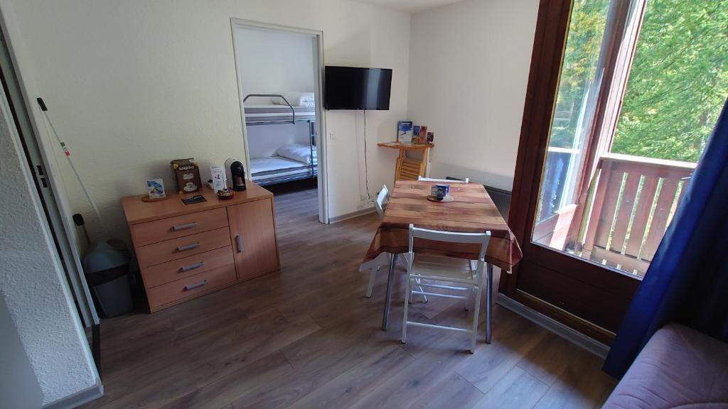 a room with a table and a dresser and a bedroom at Residence Les Ecrins in Puy-Saint-Vincent