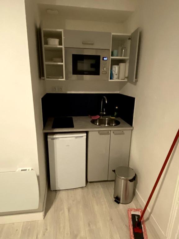 a small kitchen with a sink and a microwave at Lh Rooms Location in Le Havre