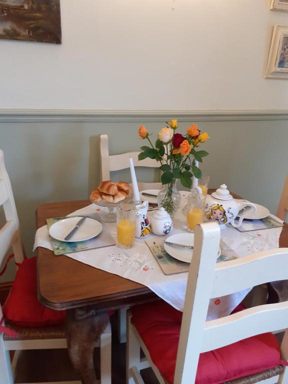 una mesa de comedor con un jarrón de flores. en Rose Cottage, en Telford