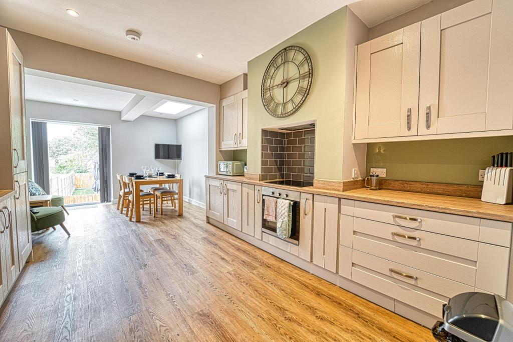 a large kitchen with a large clock on the wall at Guest Homes - Gillam House in Worcester