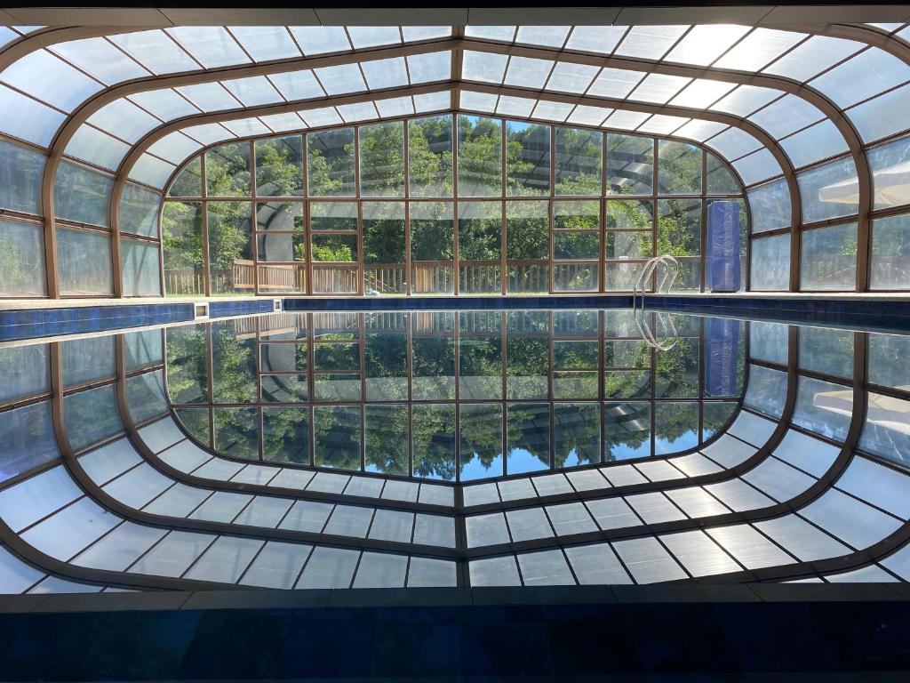 uma piscina interior num edifício com uma grande janela em Hotel Rural Vale Do Rio em Oliveira de Azemeis