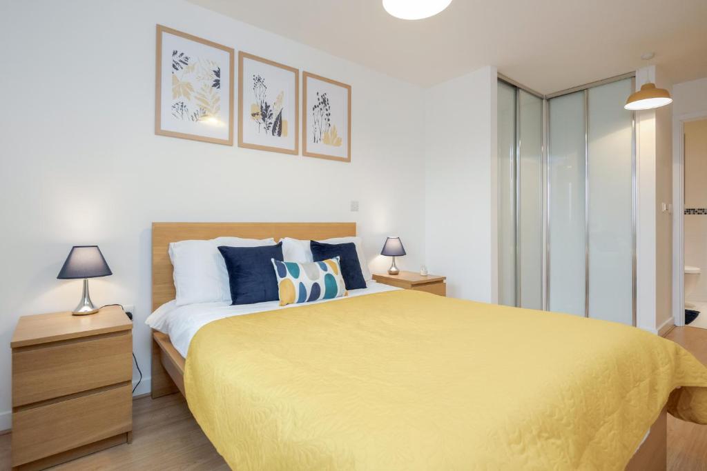 沃金的住宿－Cloud9SA at The Park Heights Woking，一间卧室配有一张大黄床和两盏灯。