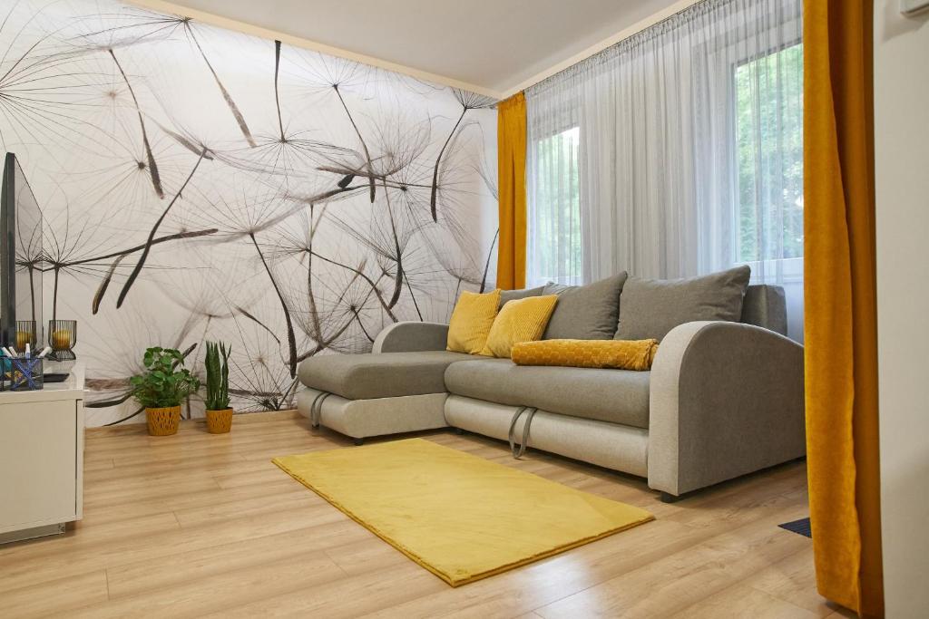 ein Wohnzimmer mit einem grauen Sofa in einem Zimmer in der Unterkunft SUNLIGHT BRONZE Plus - Szeged in Szeged
