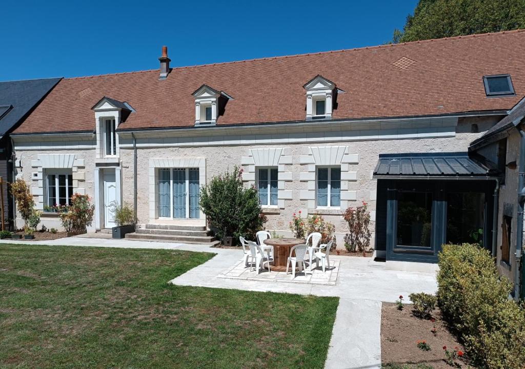 a house with a table and chairs in the yard at Sur La Route Des Châteaux in Thenay