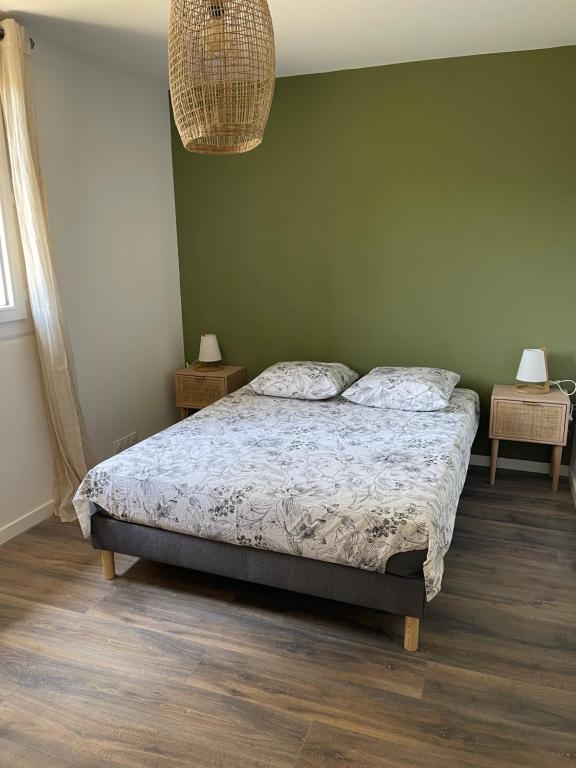 a bedroom with a bed and a green wall at Appartement en centre - résidence privée, vue mer in Porto-Vecchio