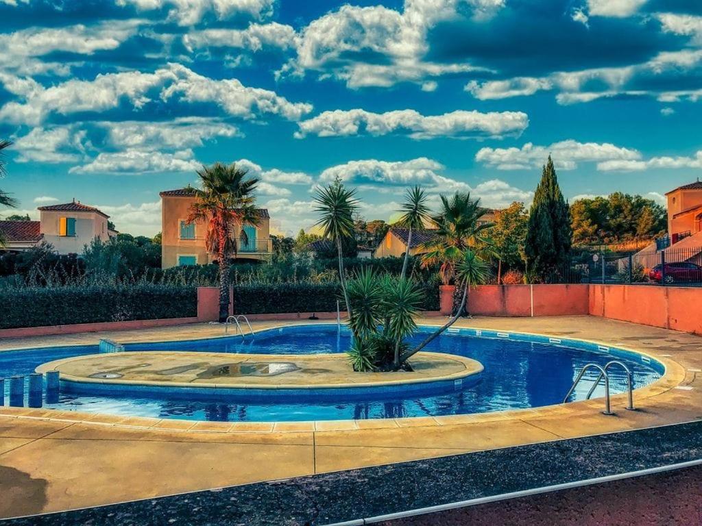 una piscina in un cortile con palme di Chez Tranquille, Apartment 43 a Montblanc