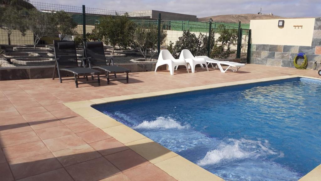 a group of chairs and a swimming pool at El cortijo de Valverde in Lajares