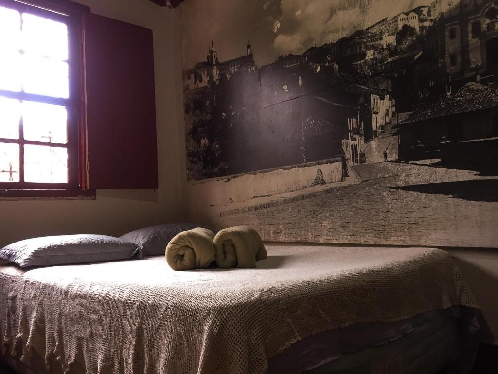 Una cama con dos toallas encima. en Nuh Hostel en Ouro Preto