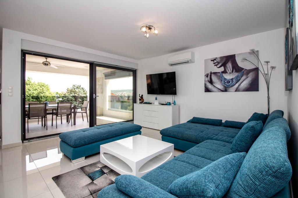 a living room with two blue couches and a table at Luxury Apartment Luna in Vantačići