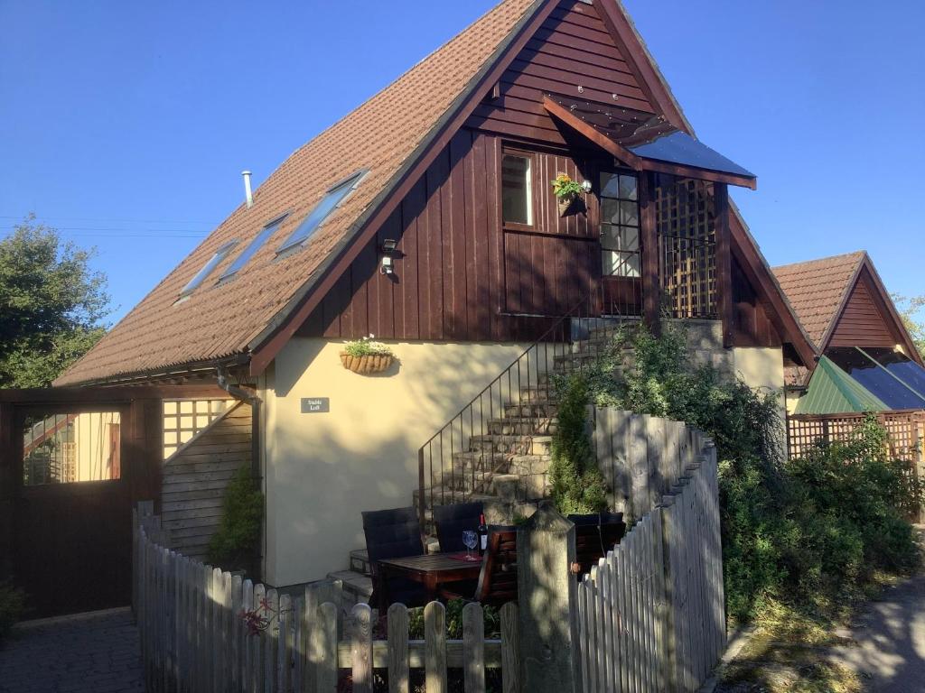 a house with a fence in front of it at Stable Loft in Winscombe