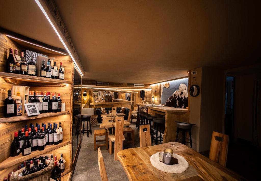 a restaurant with a table and some bottles of wine at Chalet Hotel Dragon in Breuil-Cervinia