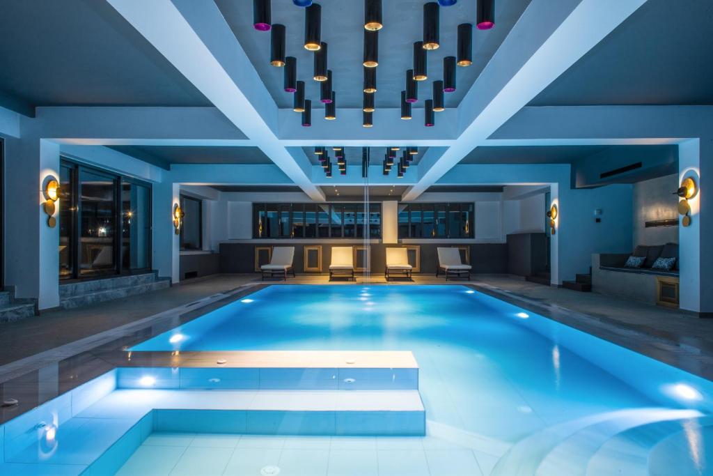 a swimming pool in a building with a chandelier at Villa Athos in Gouvia