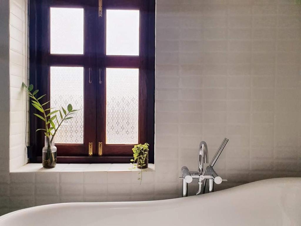 a bathroom with a bath tub and a window at Sittisang1920 in Kanchanaburi