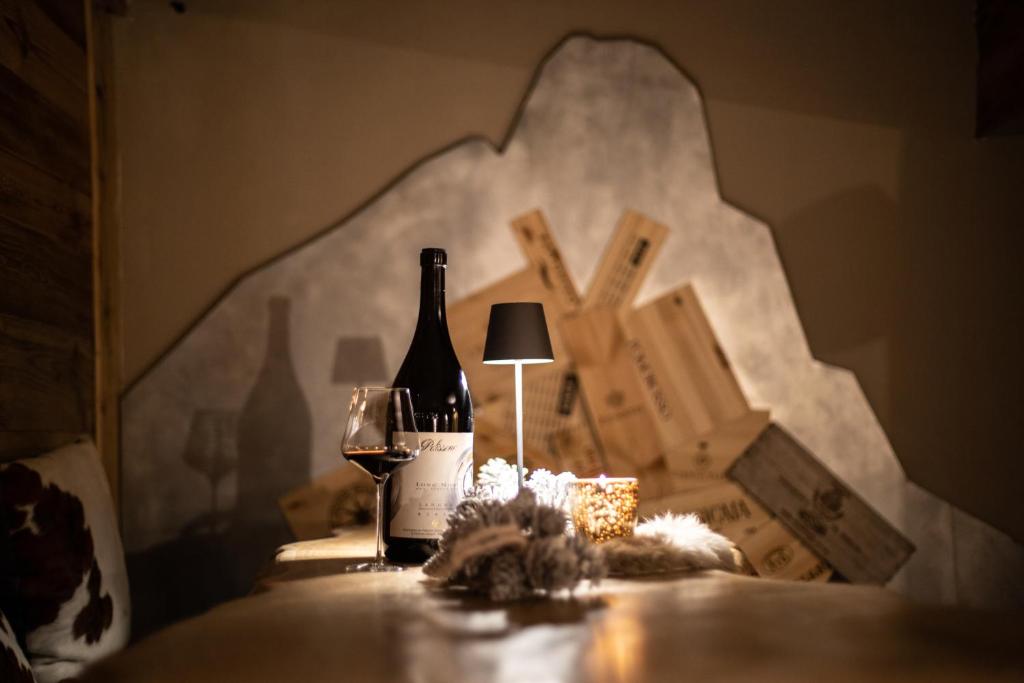 a bottle of wine and a glass on a table at Chalet Hotel Dragon in Breuil-Cervinia