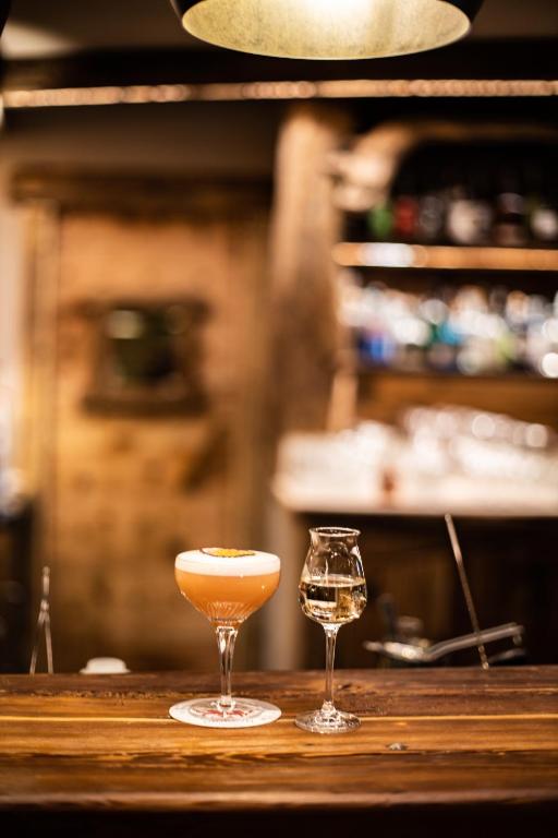 a cocktail and a wine glass on a bar at Chalet Hotel Dragon in Breuil-Cervinia