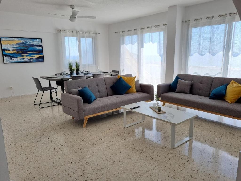 a living room with two couches and a table at Diamond Sea View Penthouse in Paphos City