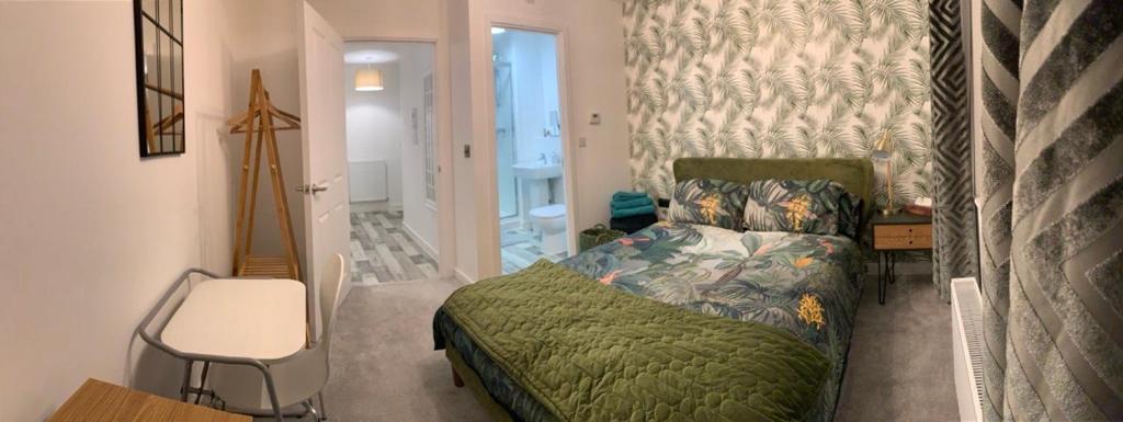 um quarto com uma cama, uma mesa e uma cadeira em Peterborough City Center One Bed apartment With Free Private Parking em Peterborough