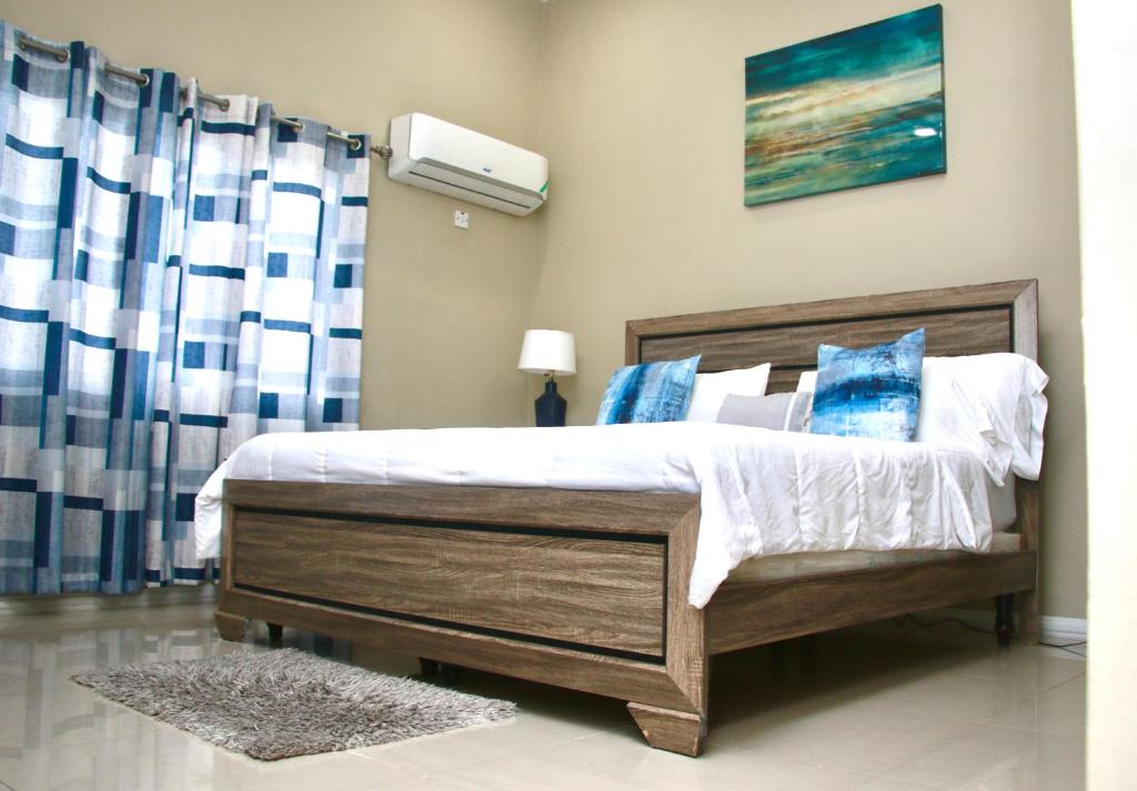 キングストンにあるComfort Homes Jamaicaのベッドルーム1室(青と白の枕が備わるベッド1台付)
