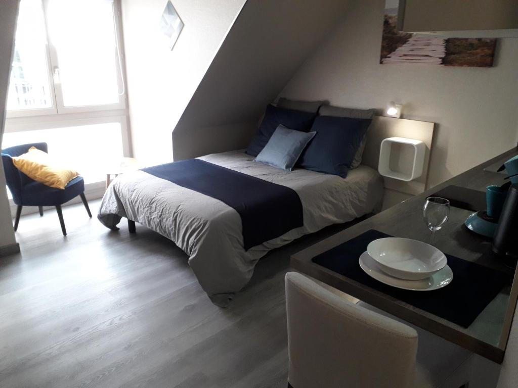 Un pequeño dormitorio con una cama y una mesa con una mesa. en Studio centre historique, place de la réunion, en Mulhouse