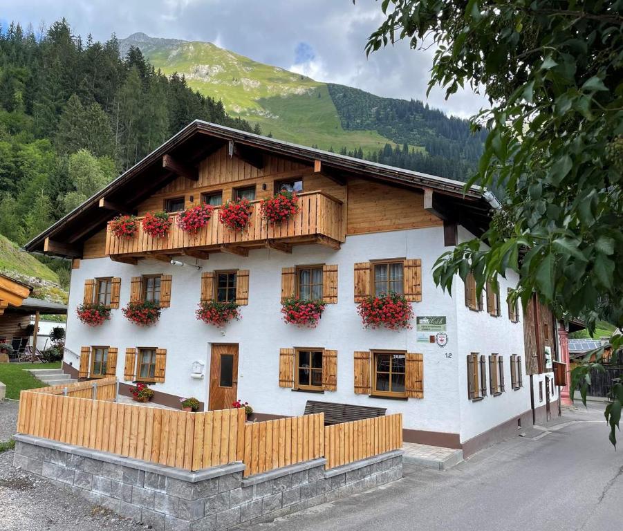 ein Gebäude mit Blumenkästen an den Fenstern in der Unterkunft Haus Walch in Elbigenalp