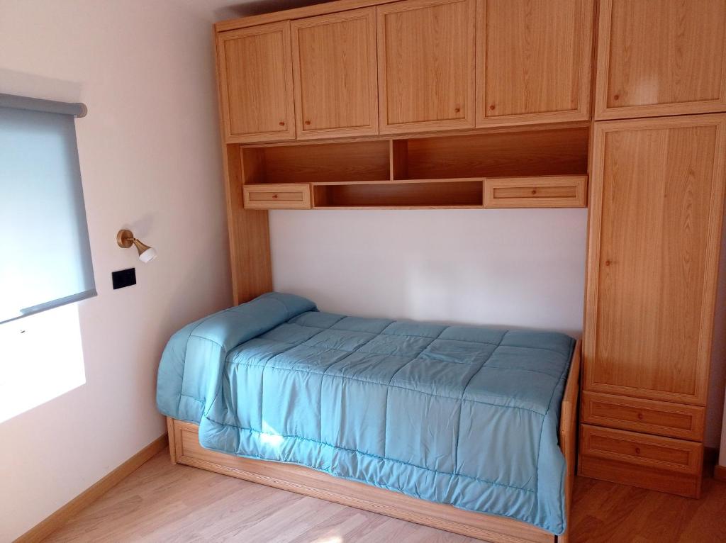 ein kleines Bett in einem Zimmer mit einem Holzschrank in der Unterkunft Casa Rural Estajero in Muñana