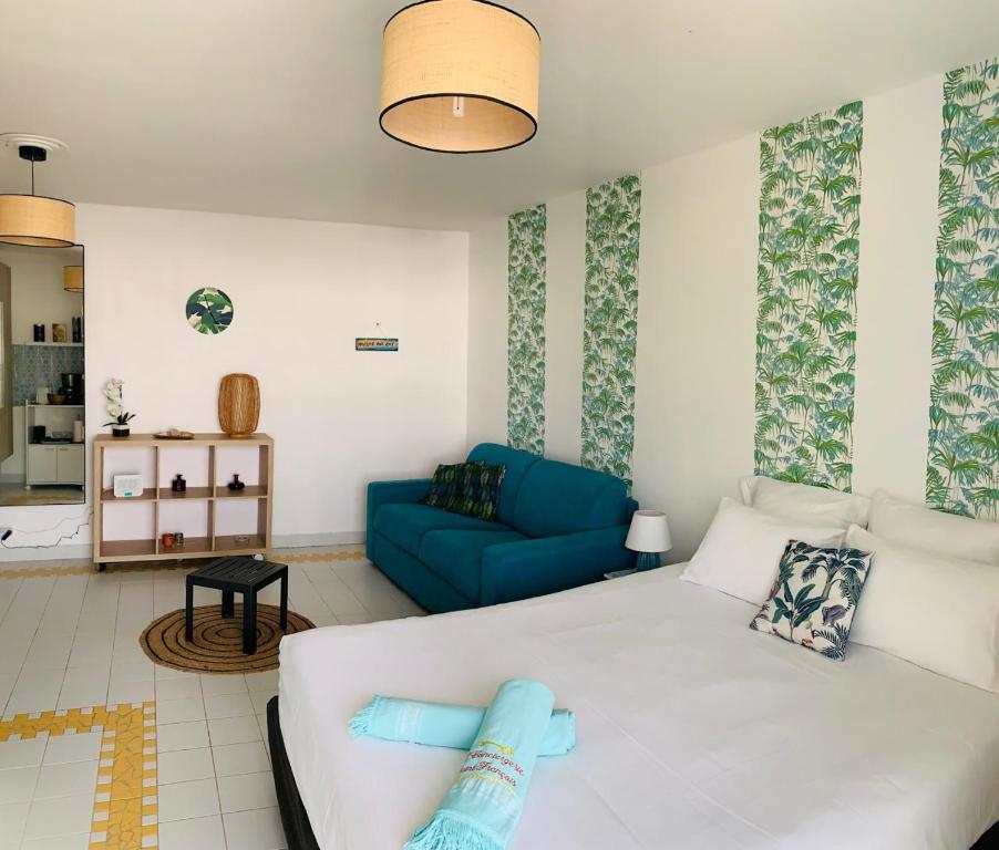 een woonkamer met een wit bed en een blauwe bank bij Studio kassav in Saint-François