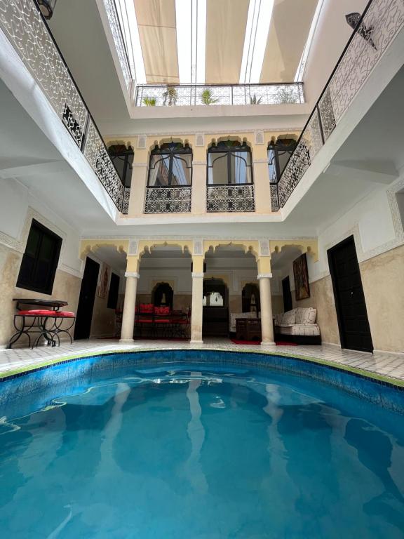 une grande piscine dans une maison avec un puits de lumière dans l'établissement Riad Miliana, à Marrakech