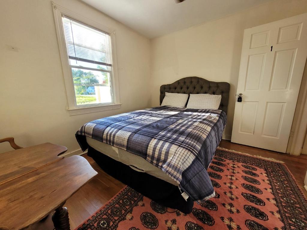 a bedroom with a bed and a table and a window at Virginia Vacation duplex house 1 in Virginia Beach
