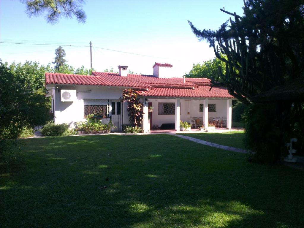 Casa blanca con techo rojo y patio en Casa Suiza en Luis Guillón