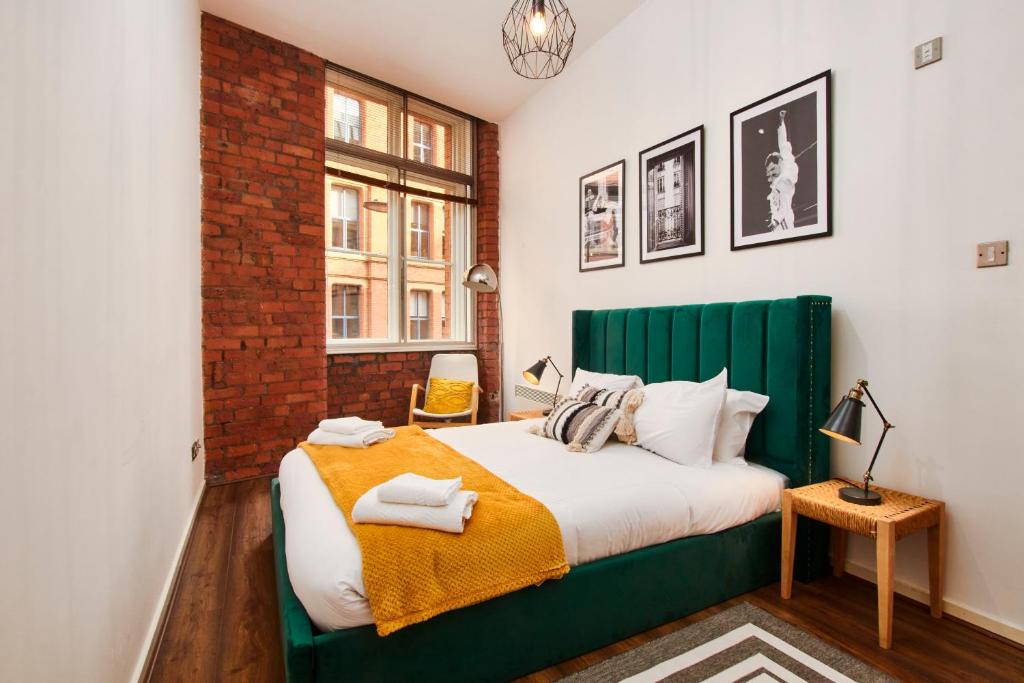 a bedroom with a green bed and a window at Lovely flat in central Manchester in Manchester