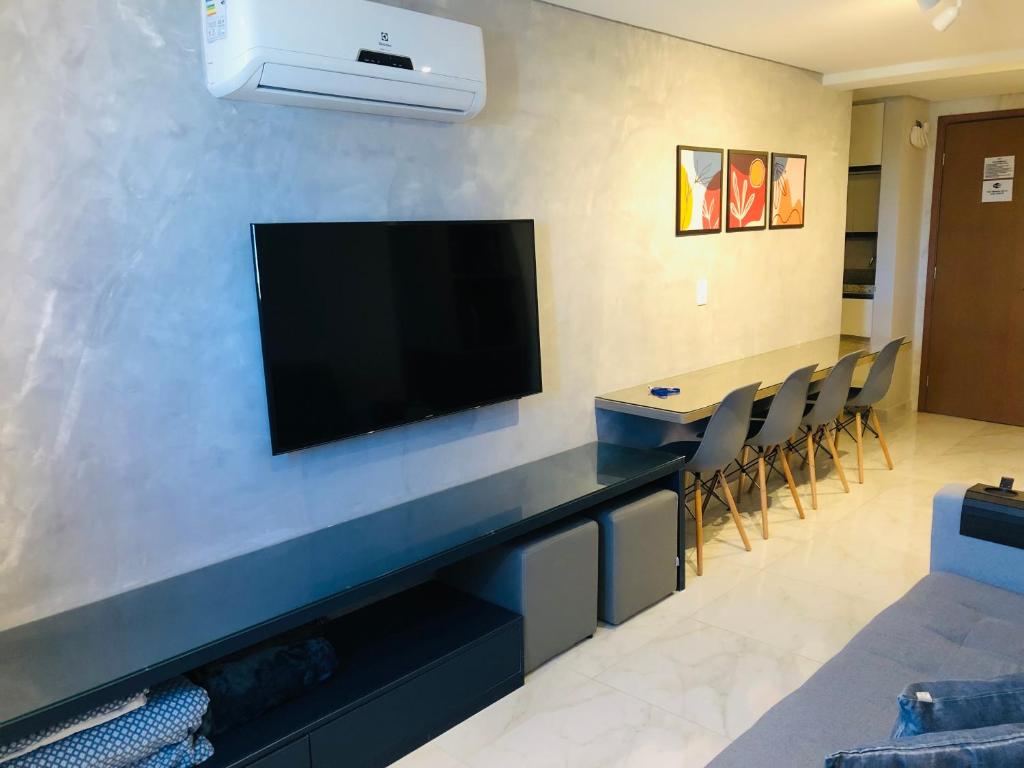 a living room with a flat screen tv on a wall at Makambira Residence By SummerFlats no CENTRO DE PORTO DE GALINHAS in Porto De Galinhas