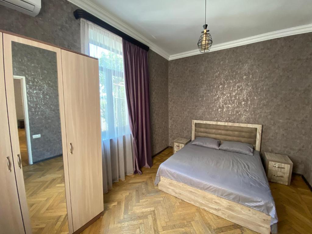 a bedroom with a bed and a large window at HovSer in Yerevan