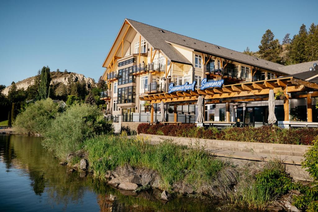 a hotel with a river in front of a building at Summerland Waterfront Resort & Spa in Summerland