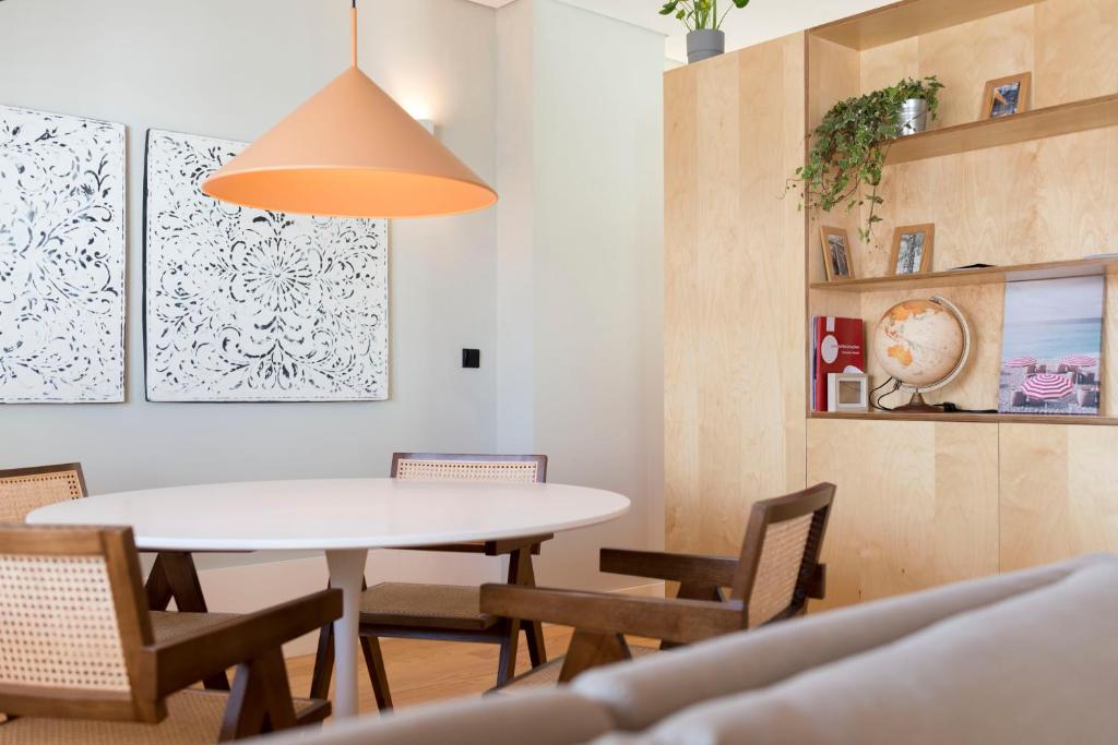 comedor con mesa blanca y sillas en Ceuta 33 Apartment, en Oporto