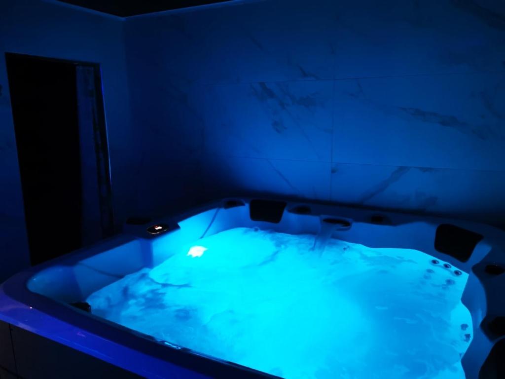 bañera con iluminación azul en una habitación en Medusa spa 34, en Montpellier