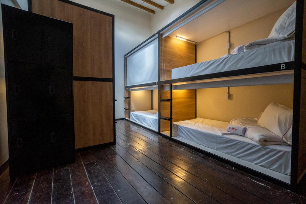two bunk beds in a room with wooden floors at The Luun Hostel in Bogotá